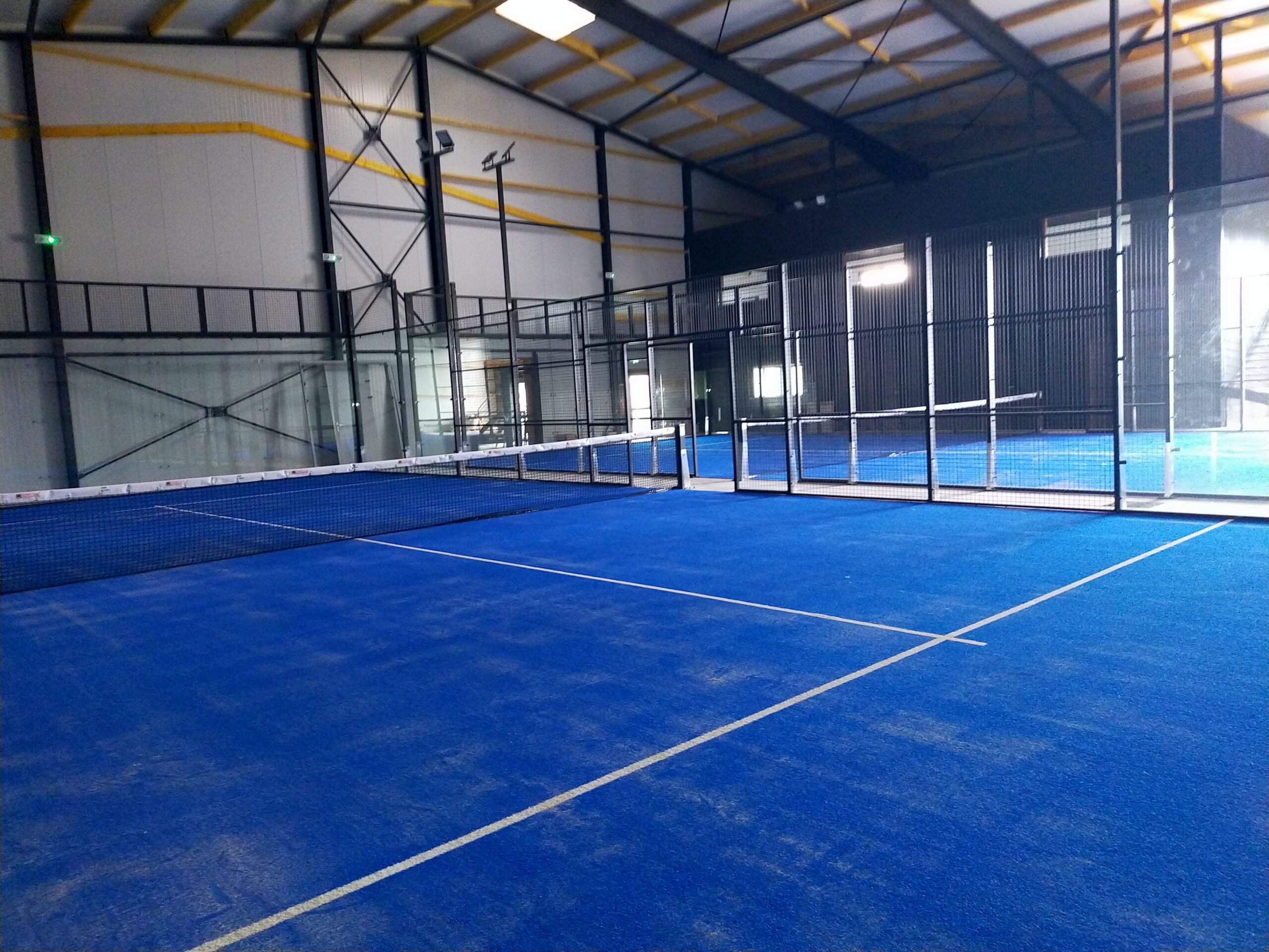 Vue d'ensemble de plusieurs terrains de padel couverts chez Indoor Padel Loudéac